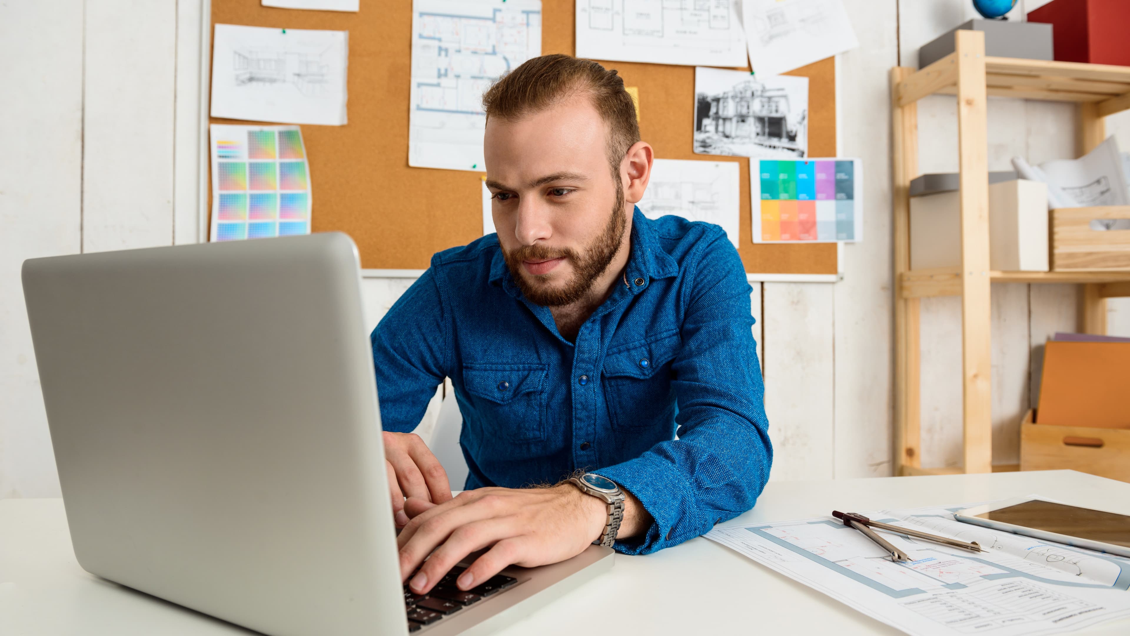 To kollegaer som sammenligner AI-verktøy på skjerm i kontorlandskap