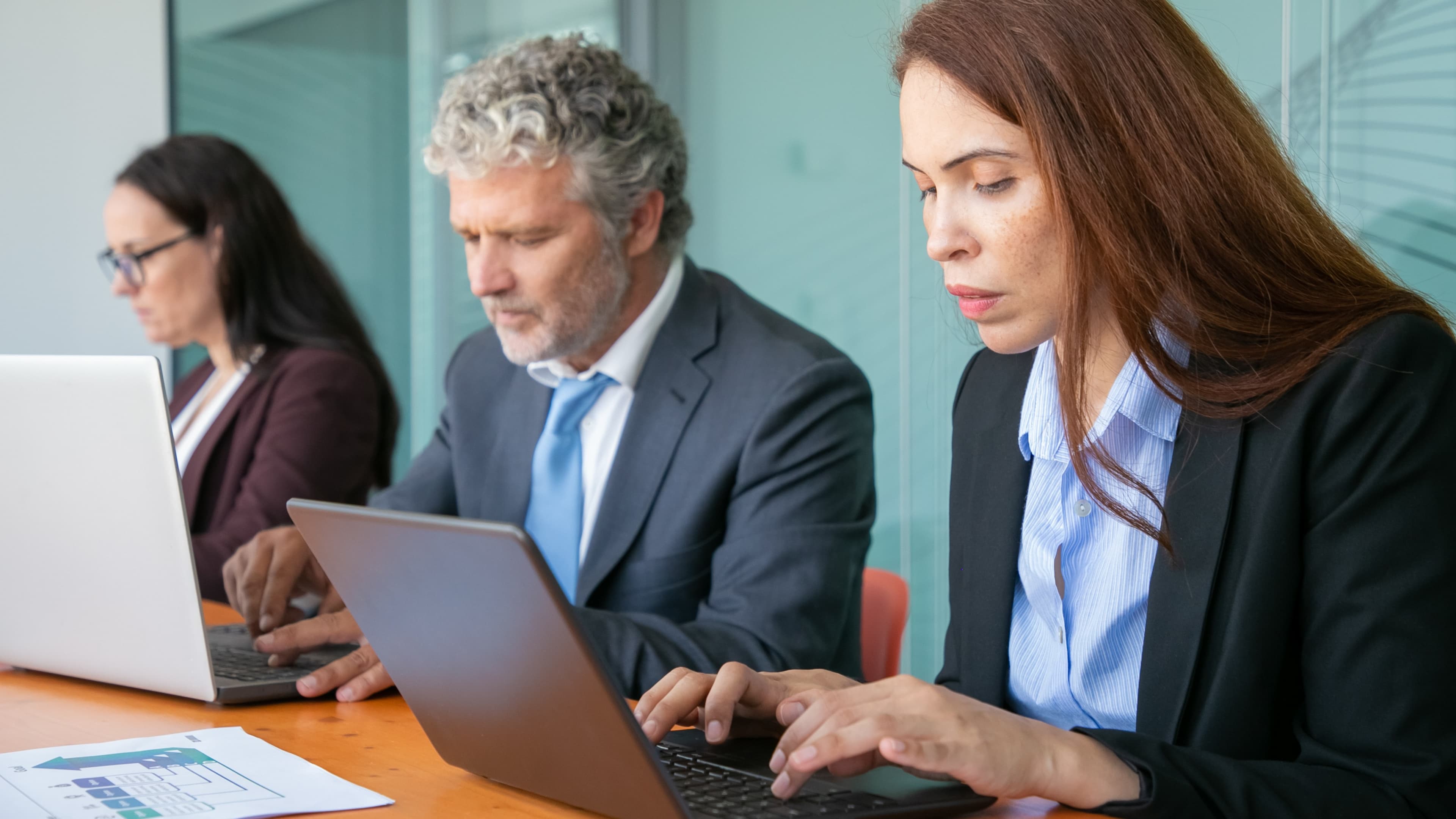 Ansatte som samarbeider rundt et bord med personalsystem på skjermen